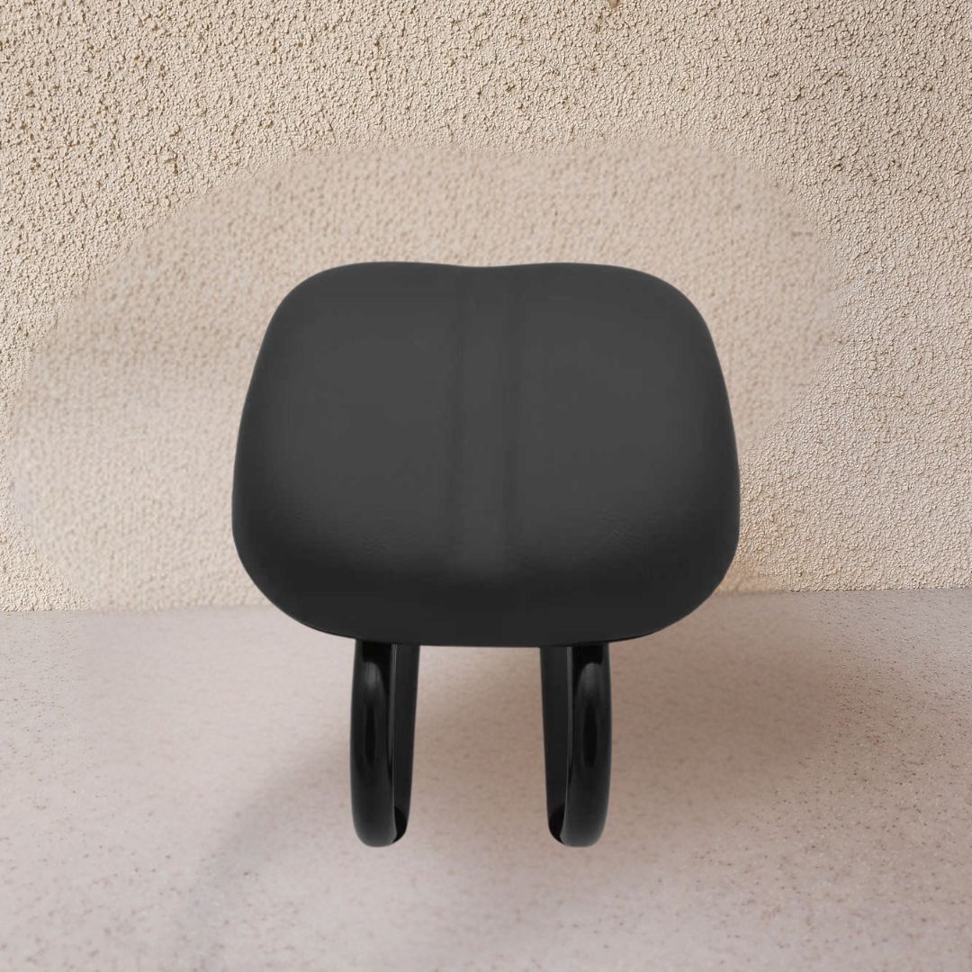Black stool with cushioned seat on a beige background
