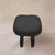 Black stool with cushioned seat on a beige background