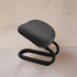 Black ergonomic chair pad on a neutral background