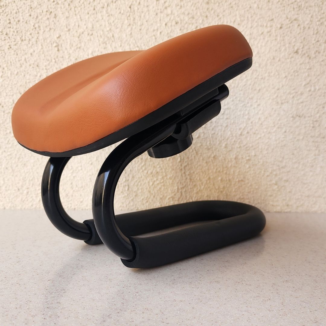 Kneeling chair with brown seat and black frame on a light surface.