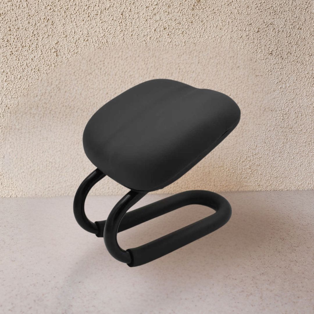 Black ergonomic chair on a light beige surface with a textured wall background