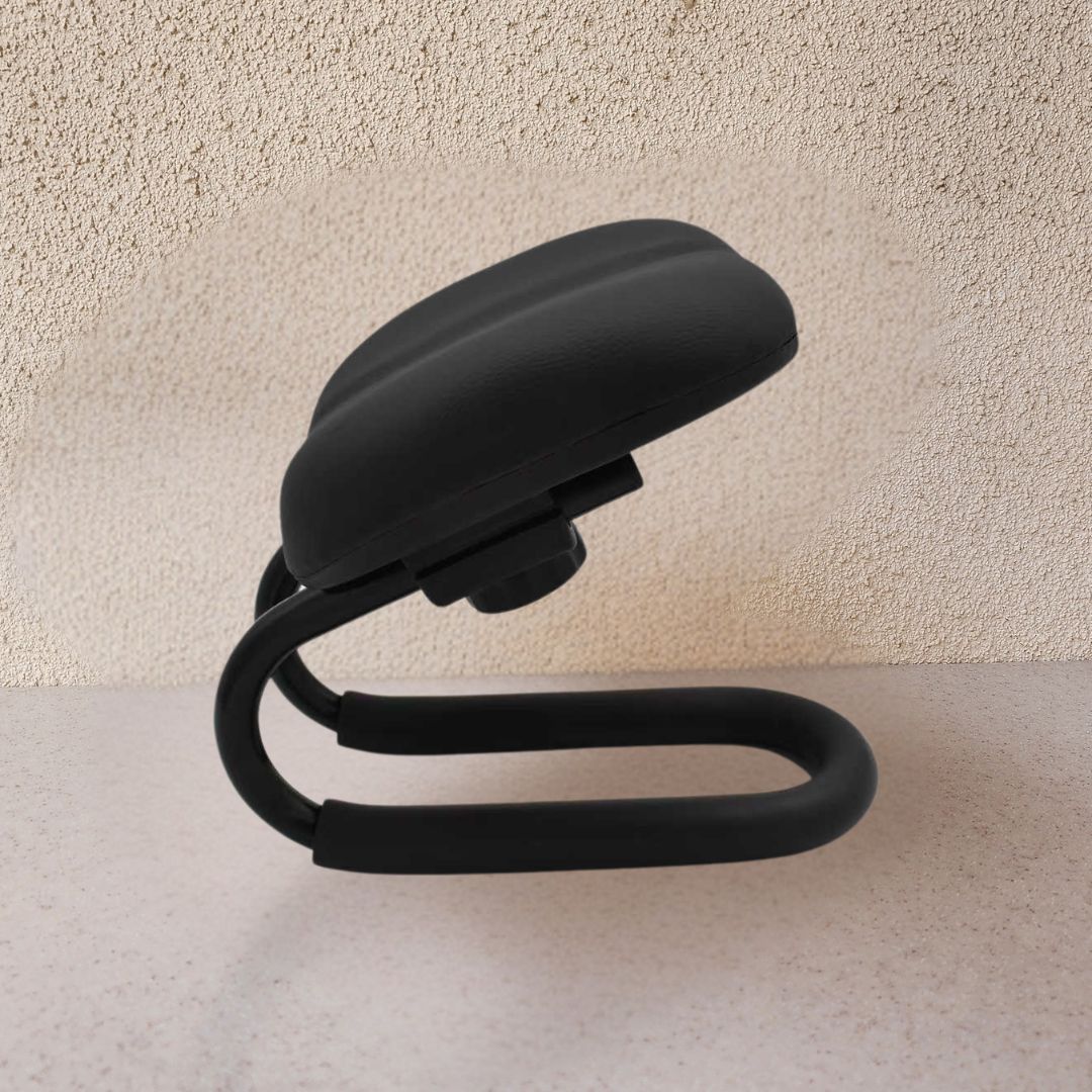 Black flexible phone stand on a light beige surface with a neutral background